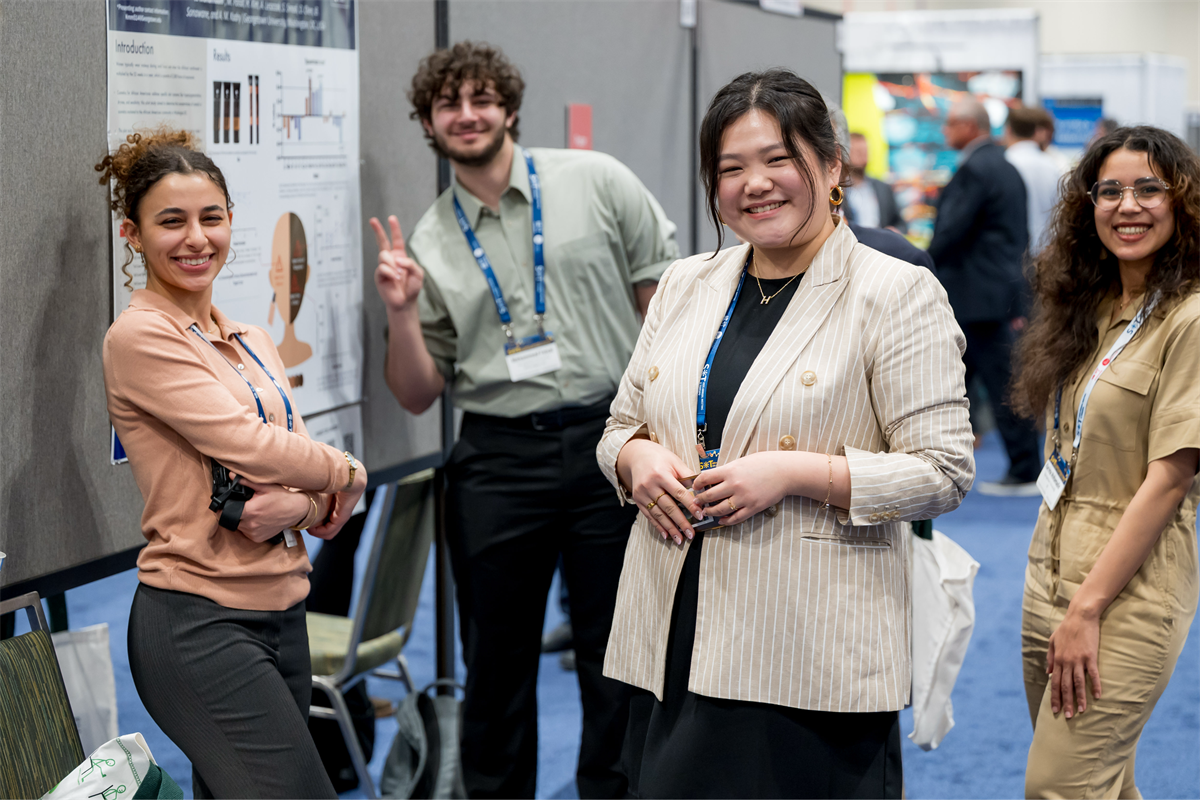 4 individuals standing at a poster session at the 2026 SOT Annual Meeting, smiling at the camera